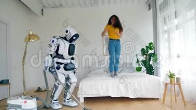快乐的女孩跳到床上，而机器人则打扫地板。 机器人，半机器人和人类概念。